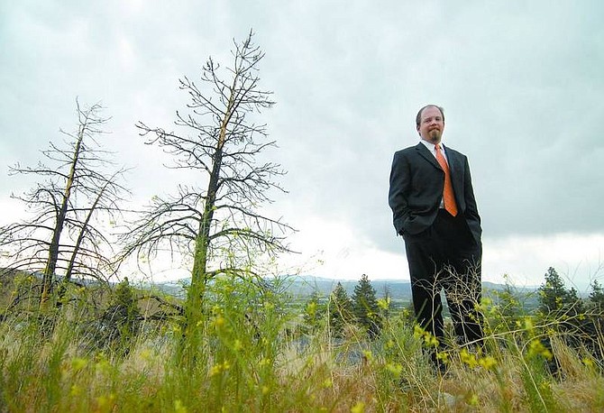 Andrew List stands near burned trees on Timberline Drive,  where several  houses in the  area were destroyed by the Waterfall fire, on Friday afternoon. List has been the executive director of the Nevada Fire Safe Council for one year and a member of the group for four years.   Kevin Clifford/ Nevada Appeal