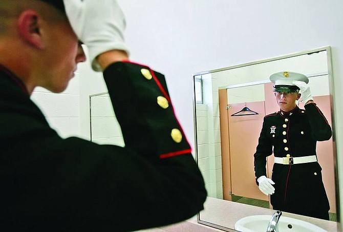 Chad Lundquist/Nevada Appeal 18-year-old Pvt. Chris Pittman, carefully looks over his dress uniform in the mirror before his graduation ceremony at the Carson City Community Center. Pittman along with 40 of his classmates graduated from Silver State Charter High School on Monday night.