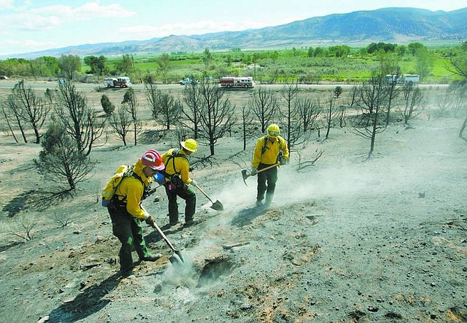 Cathleen Allison/Nevada Appeal A crew from the Sparks Fire Department extinguishes hot spots near Coleville, Calif. on Wednesday morning. The Larson fire, which grew to an estimated 1,400 acres was burning away from the town Wednesday and evacuated residents were allowed to return.