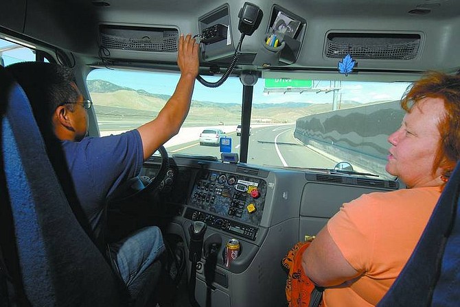 Kevin Clifford/Nevada Appeal Melquiades Rosas, left, shows Teri Zutter, director of adult basic education of Western Nevada Community College, how the radio system on the semi-truck works while driving on Highway 395 on Friday.