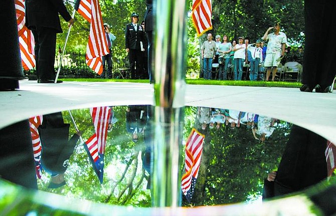ABOVE: Audience members salute the American flag during a five-flag ceremony performed by the Nevada Air National Guard&#039;s Non-Commissioned Officer Academy Graduate Association at the Veterans&#039; Memorial Wall at the State Capitol complex in Carson City on Thursday. Left: Noah Jennings gives Cindy Kirkland, the adjutant general for Nevada, a small American flag with a letter at the Nevada National Guard&#039;s Flag Day and Army birthday celebration at the Veterans&#039; Memorial Wall. Jennings, a student at St. Teresa of Avila, made these packages as part of a service project.  photos by BRAD HORN/Nevada Appeal