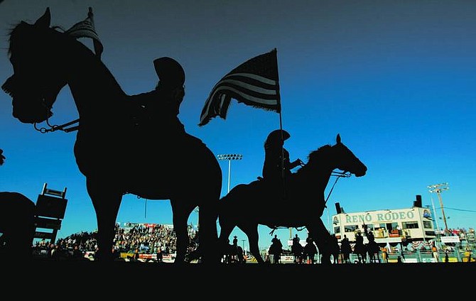 BRAD HORN/Nevada Appeal The American flag is presented during the grand entry at the Reno Rodeo on Friday at the Reno Livestock Events Center.