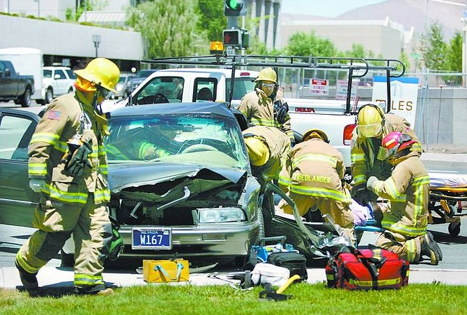 Cathleen Allison/Nevada Appeal Carson City firefighters used the Jaws of Life to cut Molly Dondero, 59, out of her vehicle Thursday following an accident at Stewart and Fifth streets. She was taken by helicopter to a Reno hospital.