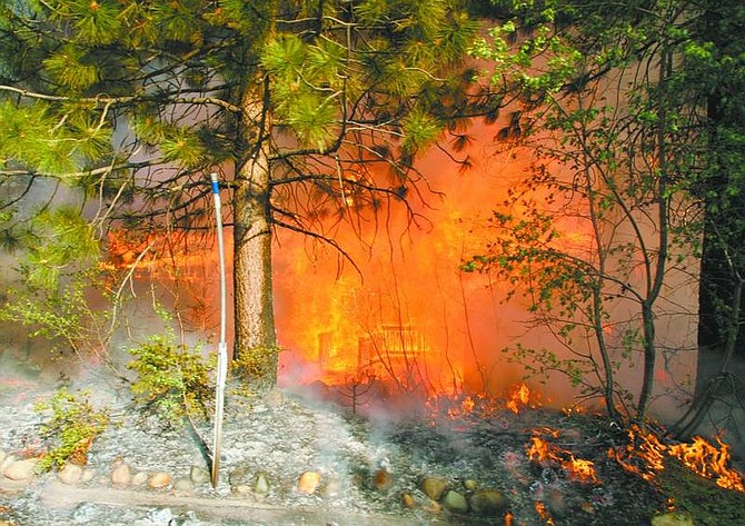 Cathleen Allison/Nevada Appeal A home in the Tahoe Mountain subdivision near South Lake Tahoe, Ca., is destroyed by the Angora fire Sunday. High winds whipped the 2,000-acre fire, destroying an estimated 165 structures. The fire remains out of control and continues to threaten more than 500 homes.