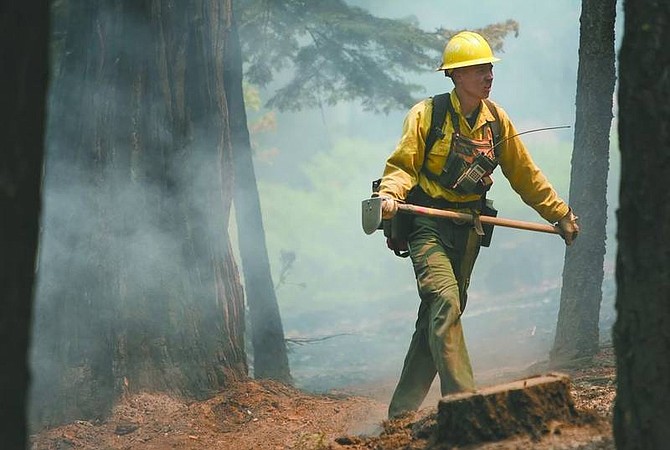 Chad Lundquist/nevada appeal A Nevada Division of Forestry firefighter works on Gardner Mountain to clear underbrush and prevent the spread of the Angora fire on Monday. Firefighters hoped to bring the blaze under control ahead of high winds and low humidity forecast for the middle of the week.