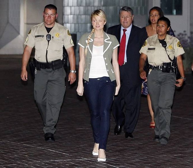 Paris Hilton escorted by Los Angeles County Sheriff deputies and her lawyer Richard Hutton, red tie, walks out of the Angeles County Sheriff Department&#039;s Century Regional Detention Facility in Lynwood, Calif., Tuesday June 26, 2007. Paris Hilton has been released from jail after serving about three weeks for an alcohol-related reckless driving case. (AP Photo/Kevork Djansezian)