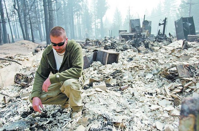 Chad Lundquist/nevada appeal Jayson Tyndall, 33, inspects the remains of his home on Lake Tahoe Blvd., Tuesday, in South Lake Tahoe. Tyndall&#039;s home was one of the first to be hit by the Angora fire which has now devastated 3000 acres.