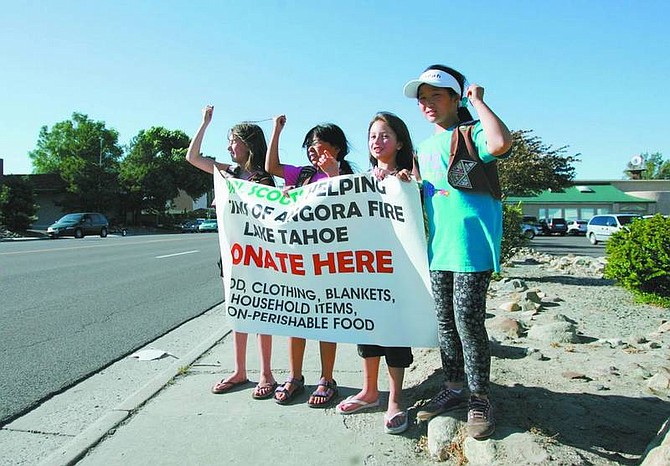BRAD HORN/Nevada Appeal GirlScouts Kaitlin Vairo, 9, from left, AnnJi Hodorowicz, 8, Kylie Riske, 9, and Lisarah Simonson, 9, try to coax a trucker into honking his horn on Carson Street on Wednesday.
