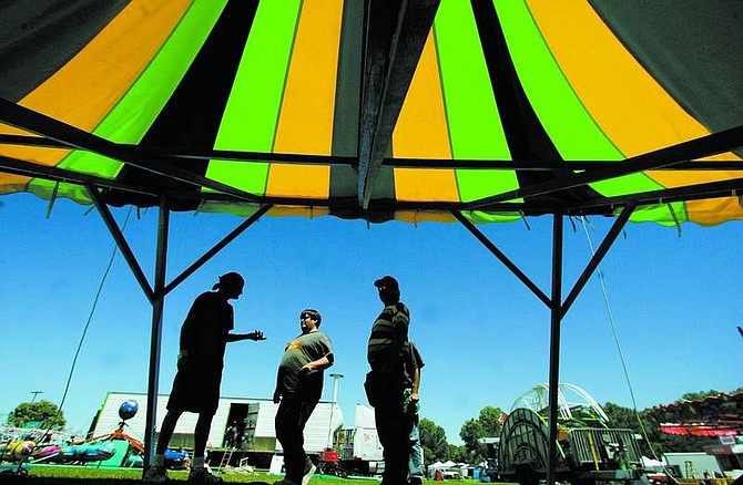 BRAD HORN/Nevada Appeal Carnival workers erect a tent at Mills Park in preparation for this weekend&#039;s carnival.