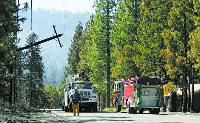 Cathleen Allison/Nevada Appeal Firefighters patrol for hot spots as utility crews begin to repair equipment damaged this week by the Angora fire in the Mount Rainier area of South Lake Tahoe.