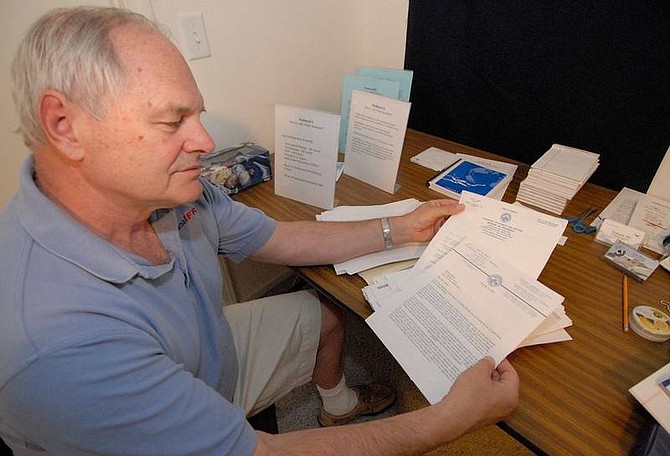 Kevin Clifford/Nevada Appeal Ed Rathje, of Stead, shows several documents on June 26 from the Department of Business &amp; Industry Division of Insurance, which he has collected information from over the years. Rathje, a citizen activist, was trying to get a bill passed which would limit the use of credit histories being used to set rates by the insurance industry.