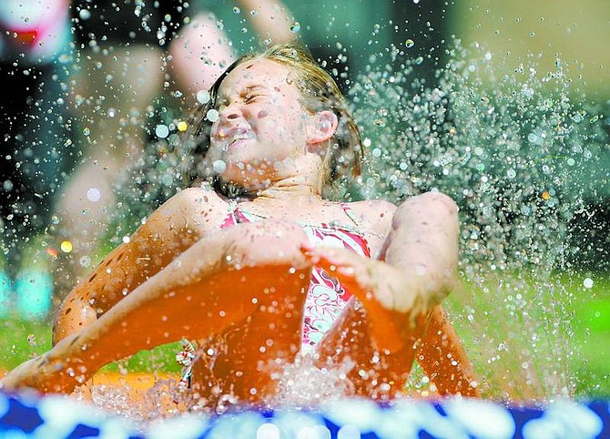 BRAD HORN/Nevada Appeal Abby Hinds, 9, of Mound House, grimaces while sliding on a slip-and-slide during water day at the Boys &amp; Girls Club of Western Nevada last Friday.