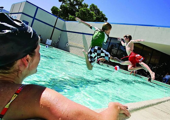 Chad Lundquist/Nevada Appeal Michelle LaFontaine, left, watches Spencer Olson, 9, and Reed Lequerica, 8, jump into the pool at the Carson City Aquatic Center on Tuesday afternoon.