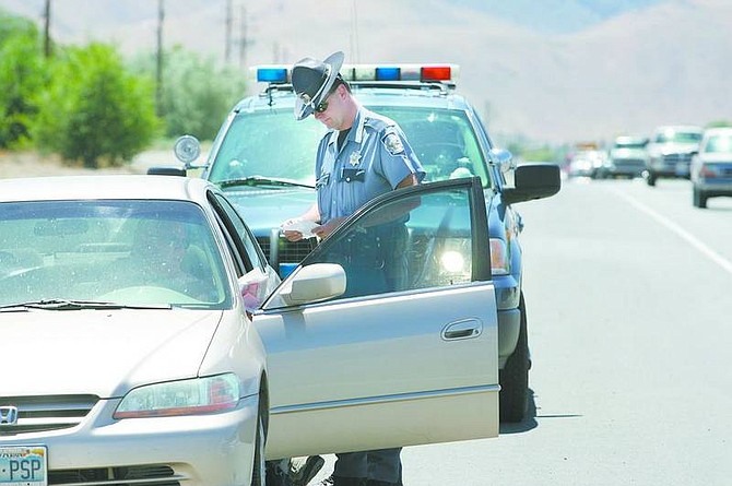 Cathleen Allison/Nevada Appeal Nevada Highway Patrol Trooper Scott Simon talks with a driver during a traffic stop Tuesday afternoon in Carson City. An increase in troopers and deputies on the streets through Monday, and a DUI checkpoint in Incline Village, are being paid for by grants.