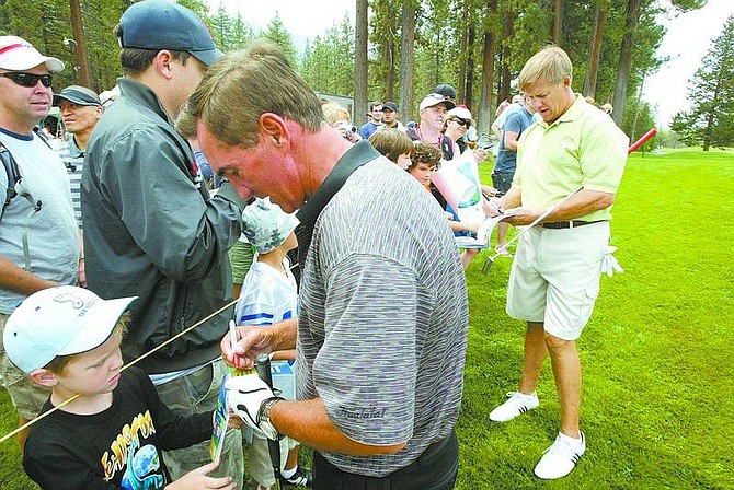 Photos by Dan Thrift / Tahoe Daily Tribune Bottom, Denver Broncos Head Coach Mike Shanahan, left, and NFL Hall of Fame Quarterback, and former Bronco, John Elway are besieged by autograph hounds Wednesday at Edgewood Tahoe Golf Course during the American Century Championship. Top, NFL Hall of Fame Quarterback John Elway chips onto the gree of hole 9 Wednesday during the American Century Championship at Edgewood Tahoe Golf Course.