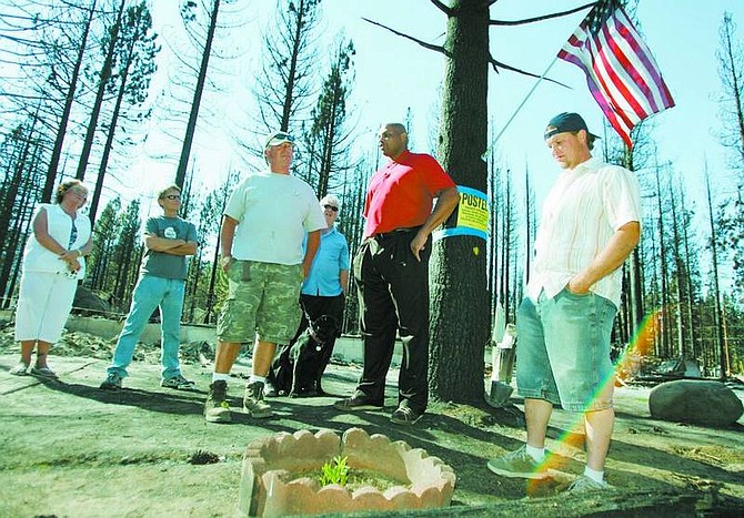 Brad Horn/Nevada Appeal Charles Barkely, in red, talks with Angora fire victim Tony Colombo, in shorts center, at the site of Colombo&#039;s destroyed home on Olympia Circle in South Lake Tahoe, Calif., during a media tour of the area on Friday. Barkley donated $25,000 to Angora fire victims and plans to take 100 firefighters to dinner today. Colombo said that the plant in the foreground, a Stargazer Lily, is the only thing that survived the fire. They named the plant Phoenix, but after Barkley visited the site they changed its name to Phoenix Barkley, referring to Barkley&#039;s days with the Phoenix Suns.