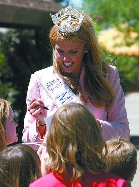 Trevor Clark/Nevada Appeal Miss Nevada, Caleche Manos, signing photos for children at the Boys &amp; Girls Club on Stewart Street on Friday.