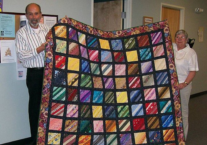 Barbara Tonge/For the Nevada Appeal Charles Daniels, Carson City Senior Citizens Center senior services manager, and Kayette Jernberg, of Capitol Quilters, display the opportunity quilt donated by the quilters to the Meals on Wheels Program for a fundraiser.