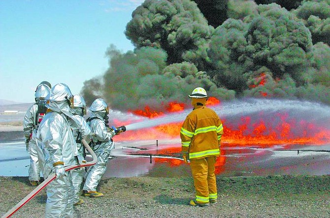 Steve Ranson/Nevada Appeal News Service Turkmen firefighters douse a jet fuel fire at the Naval Air Station Fallon pit as part of their hands-on training recently.