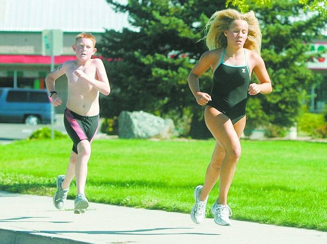 Photos by BRAD HORN/Nevada Appeal From left, Caleb Keith, 12, and Monica Herrera, 12, both of Reno, battle during the final stretch during the Capital City Kids Triathlon at Mills Park on Saturday. Herrera won the race.