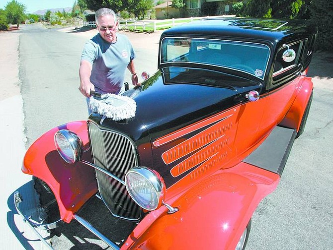 Cathleen Allison/Nevada Appeal Ray Zaro dusts off his 1932 Ford two-door sedan Friday outside his south Carson City home. Zaro and number of the Silver Dollar Car Classic participants will visit Carson Plaza Retirement Center today to display their cars and enjoy root beer floats.
