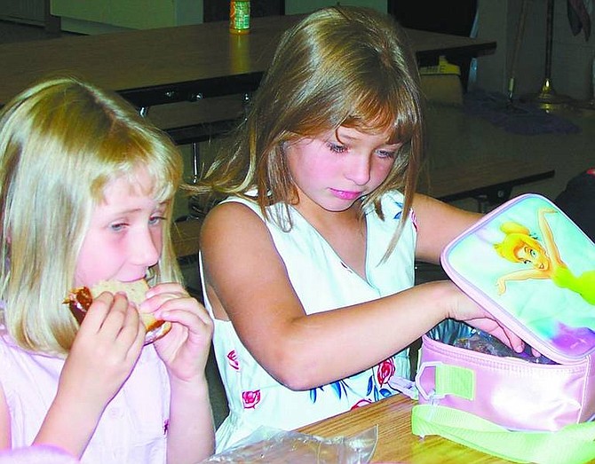 Karen Woodmansee/Nevada Appeal First-graders Chelsea Nevin, left, and Kaitlyn Hames, spend their lunch period together on the first day of school at Hugh Gallagher Elementary School in Virginia City on Monday.