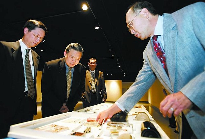 Dr. Eugene Hattori, right, curator of anthropology at Nevada State Museum shows Consulate General Peng Keyu, center, and Deputy Consulate General Shen Weilian, left, of the People&#039;s Republic of China in San Francisco, Chinese artifacts collected from the region at the museum on Wednesday.  Chad Lundquist/Nevada Appeal