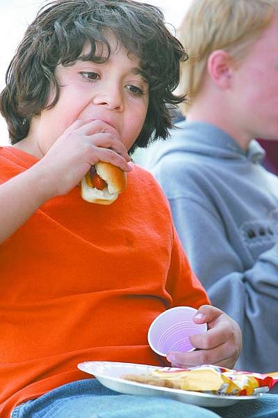 Cathleen Allison/Nevada Appeal Anthony Abundis, 11, enjoys a barbecue hosted by the Dayton Community Task Force on Wednesday at the Dayton Library.