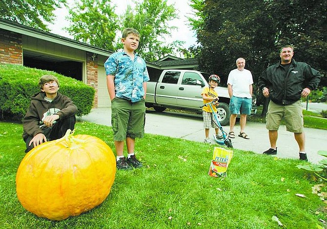 BRAD HORN/Nevada Appeal Pictured from left are Matthew Hanzlik, Chris Hanzlik, Nathan Hanzlik, Mark Hanzlik and Brian Hanzlik. Chris planted pumpkin seeds in June and grew this 86-pound squash fruit.