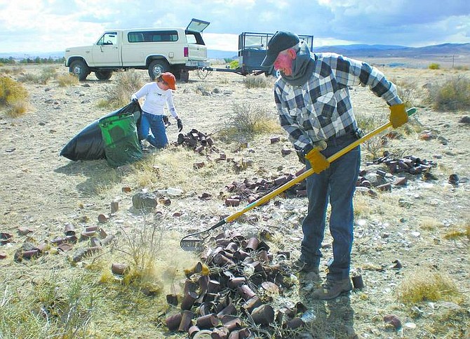 Photo courtesy of Tami Daniels                      Marialaina Batoog and Andy Quinn clean up cans and broken bottles Saturday in Stockton Flat in Stagecoach as part of National Public Lands Day.