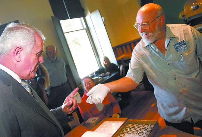 Trevor Clark/Nevada Appeal Chief Coiner Ken Hopple shows Gov. Jim Gibbons one of the first mints of the 100-year anniversary medallion commemorating the University of Nevada, Reno&#039;s Mackay School of Earth Sciences and Engineering at the Nevada State Museum on Monday.