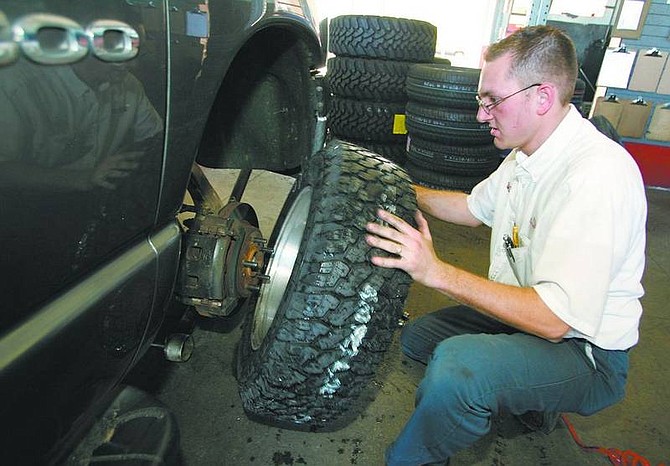 Derek Marlatt, assistant manager at Les Schwab Tire Center, changes a tire Monday afternoon at the South Carson City store. Proper tires are just one of the things experts remind drivers to be aware of for safe winter travel.  Cathleen Allison/ Nevada Appeal