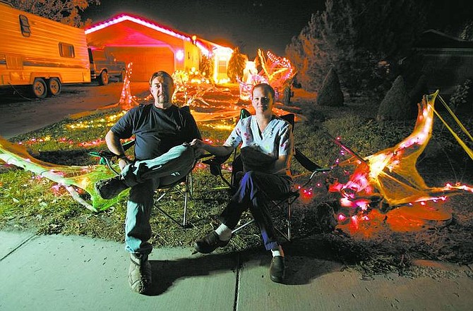 BRAD HORN/Nevada Appeal Jon and Sharry Goeschi sit in front of their home at 670 Occidental Drive on Friday evening. Jon is a senior tech at Hodges Transportation and Sharry is a CNA and RN for a hospice company in Reno. Jon Goeschi starts decorating his home for Halloween on Oct. 1.