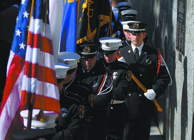 Kevin Clifford/Nevada Appeal Firefighter Honor Guards from Las Vegas, Clark County and Sparks enter the Nevada Firefighter Memorial Service at Mills Park on Saturday.