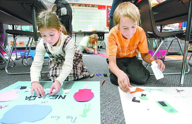 Cathleen Allison/Nevada Appeal Fritsch Elementary School third-graders Jia Wong-Fortunado, 8, and Mark Huckabay, 9, work on their posters Wednesday. Nevada Commission on Tourism Director Tim Maland chose Wong-Fortunado&#039;s poster as the contest winner.