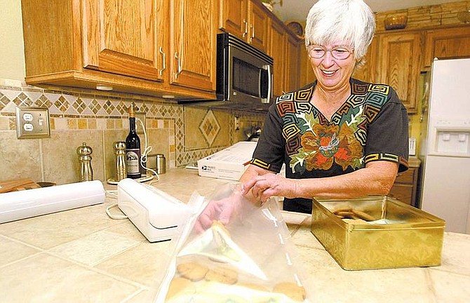Shannon Litz/Appeal News Service Helen Taylor vacuum seals a batch of cookies to send to Iraq on Oct. 11.