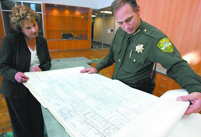 Cathleen Allison/Nevada Appeal Carson City Sheriff Kenny Furlong and business manager Kathy Heath look through blueprints of the Sheriff&#039;s Department, unearthed Monday from a time capsule buried in 1966. AT TOP: Furlong holds pennies found in the time capsule.