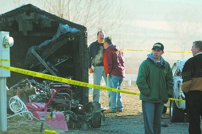 BRAD HORN/Nevada Appeal Carson City Sheriff&#039;s Lt. Bob White, in red, and Carson City Fire Chief Stacey Giomi, investigate a shed fire where a small body was found Saturday morning. Investigators believe the victim was a 9-year-old boy.