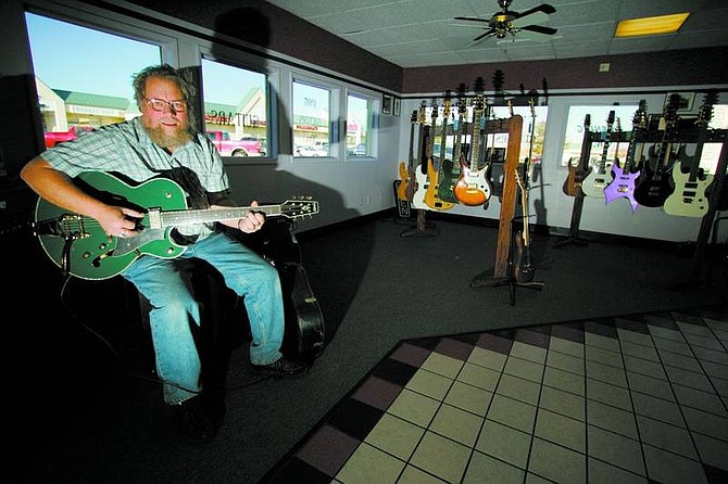 BRAD HORN/Nevada Appeal Dan Linn plays a Spirit custom jazz box at the Carson City store on Wednesday. Bono, lead singer of the Irish rock band U2, recently played a Spirit guitar during a television concert. Spirit guitars are made in Gardnerville.