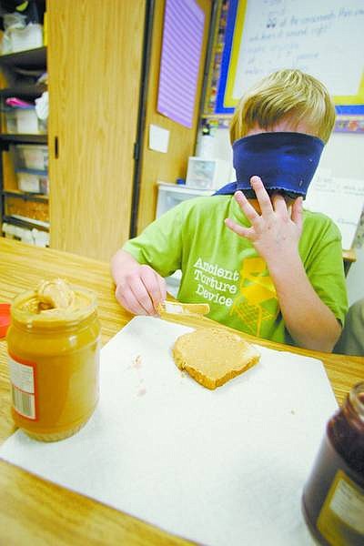 BRAD HORN/Nevada Appeal Brent Roberts, 10, makes a peanut butter and jelly sandwich with a blindfold at Fremont Elementary School on Wednesday. Gifted and talented students were learning what it is like without sight.