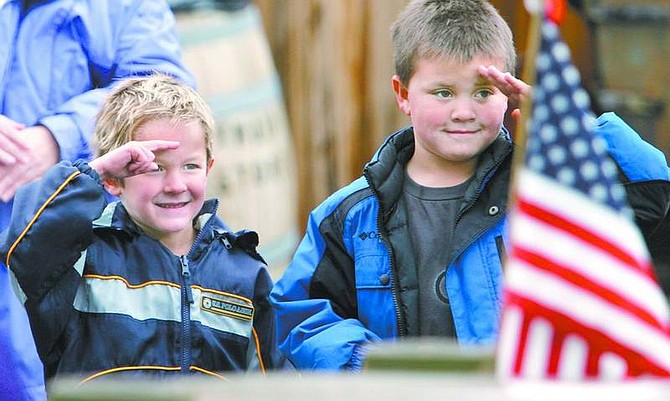 Cathleen Allison/Nevada Appeal Evan Parsons, 5, left, and Tyler Curtis, 7, salute a group of veterans in the Virginia City Veterans Day Parade on Sunday.