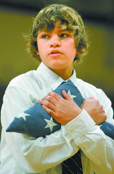 Jacob Branco, 13, holds a flag folded during the flag retirement ceremony. Students honored local veterans and folded flags to be presented for retirement.