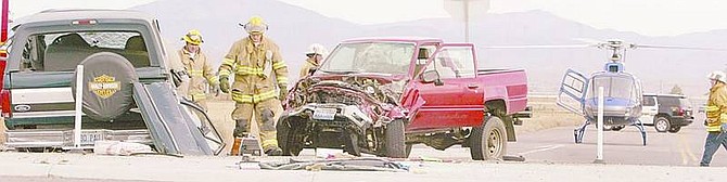 Sarah Hall/Nevada Appeal News Service Fire officials investigate the scene of a collision involving two cars at the intersection of Airport Road and Highway 395 in Carson Valley Monday afternoon.