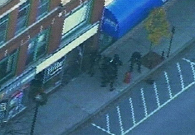 In this image taken from AP Television News, S.W.A.T.  team members approach the door of Hillary Rodham Clinton&#039;s campaign office in Rochester, N.H., Friday Nov. 30, 2007. A man claiming to have a bomb walked into a Clinton campaign and took at least two hostages, police and witnesses said. (AP Photo/APTN)