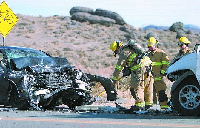 Amy Lisenbe/Nevada Appeal Carson City firefighters work to clear debris from a head-on collision in the north bound lane of Fairview Drive just south of Butti Way Sunday afternoon.