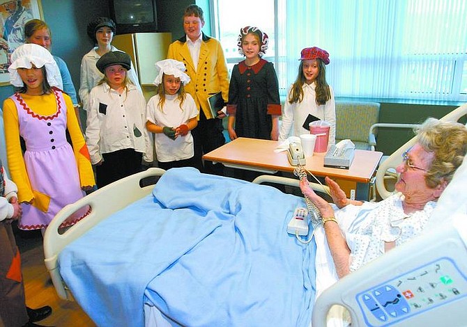 Amy Lisenbe/Nevada Appeal Hazel Parkins, right, a Carson Tahoe Regional Medical Center patient, claps as &quot;Oliver!&quot; cast members from the Lake Tahoe Shakespeare Festival and Nevada Shakespeare Company sing in her room Sunday afternoon. To view a photo album of the event visit www.nevadaappeal.com.