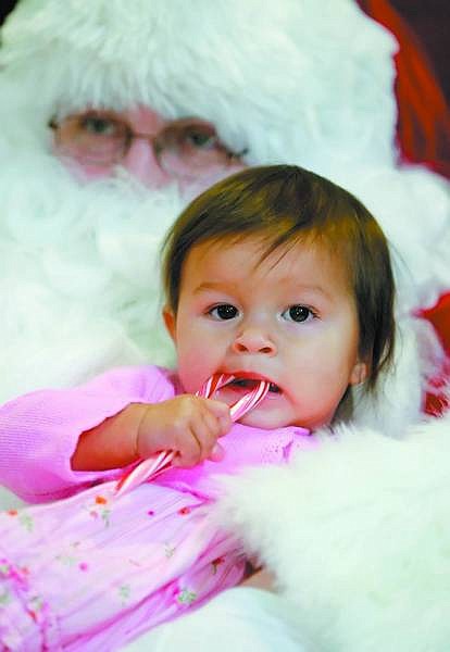 BRAD HORN/Nevada Appeal Eva Lindbloom, 15-months, of Dayton, sits with Santa Claus at the Children&#039;s Museum of Northern Nevada on Saturday. Marilyn Lewis, a Carson State Farm agent, sponsored Santa&#039;s visit to the museum.