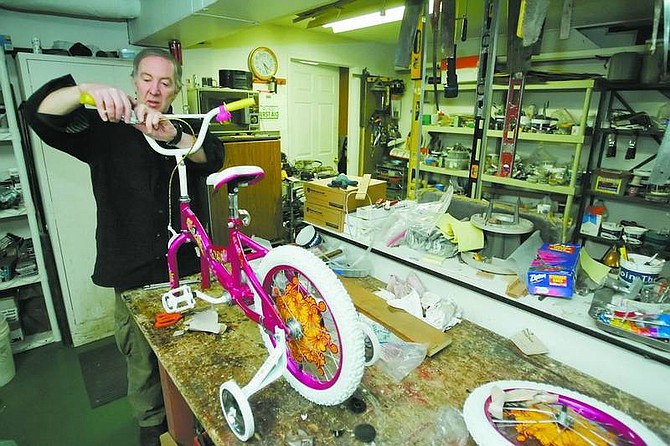 Hanifin&#039;s Antiques owner Michael Robbins assembles a girl&#039;s bike in a back room at his Carson City store on Friday. Robbins and Vera Treat donated 25 box toys and 18 bikes to the Toys for Tots program.   BRAD HORN/Nevada Appeal