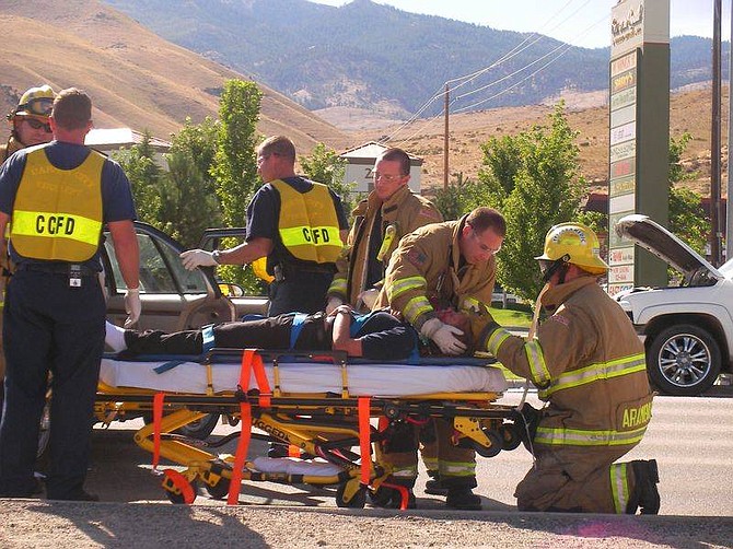Carson City paramedics treat a young woman injured in an accident at Carson and Colorado streets this afternoon