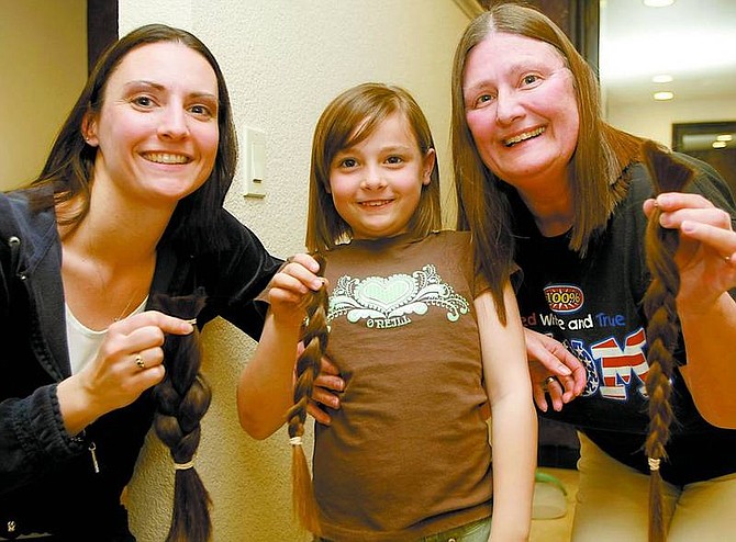 Michelle Van Geel, Nicole Van Geel, 7, and Regina Erb with their ponytails on March 11 at C &amp; Company.  Shannon Litz/Nevada Appeal News Service